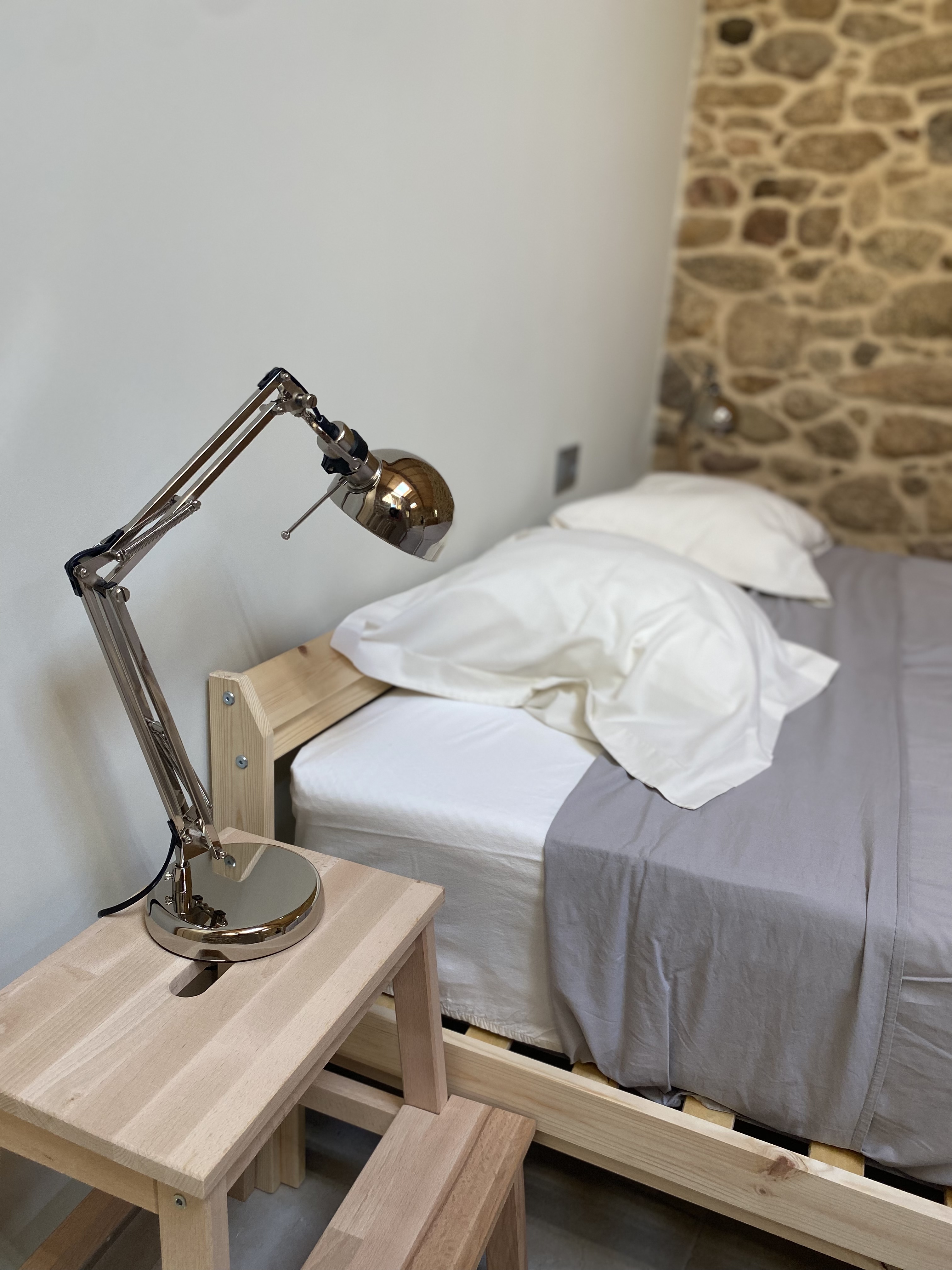 Dormitorio con piedra y madera en Portosín